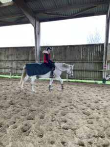 Verde avec son couvre rein et Cécile dans le manège